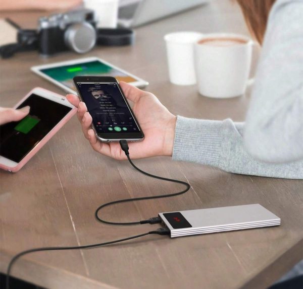 Power bank φορτίζει κινητά τηλέφωνα πάνω σε ξύλινο τραπέζι.