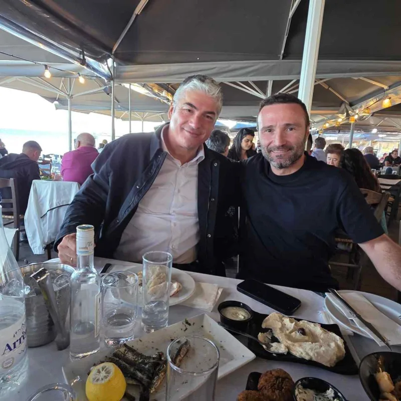 Δύο άνδρες σε τραπέζι εστιατορίου κατά τη διάρκεια γεύματος.
