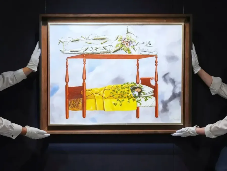 Πίνακας της Frida Kahlo με τίτλο Το Όνειρο μέσα σε κορνίζα που κρατούν δύο άτομα με λευκά γάντια.