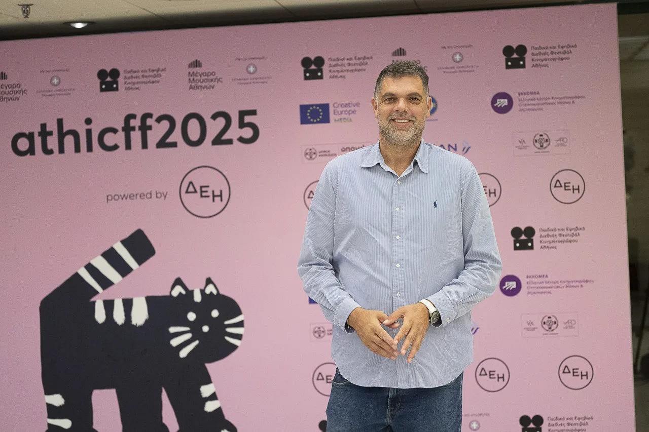 Άνδρας μπροστά από ροζ φόντο με το λογότυπο athicff2025.