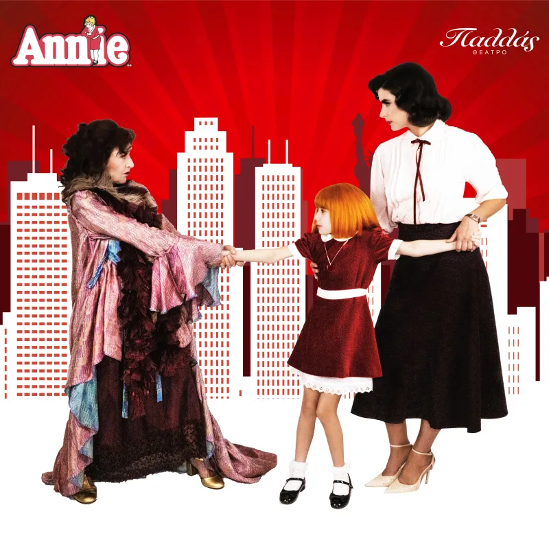 Προωθητική φωτογραφία για το μιούζικαλ Annie με τρεις ηθοποιούς σε φόντο με ουρανοξύστες.