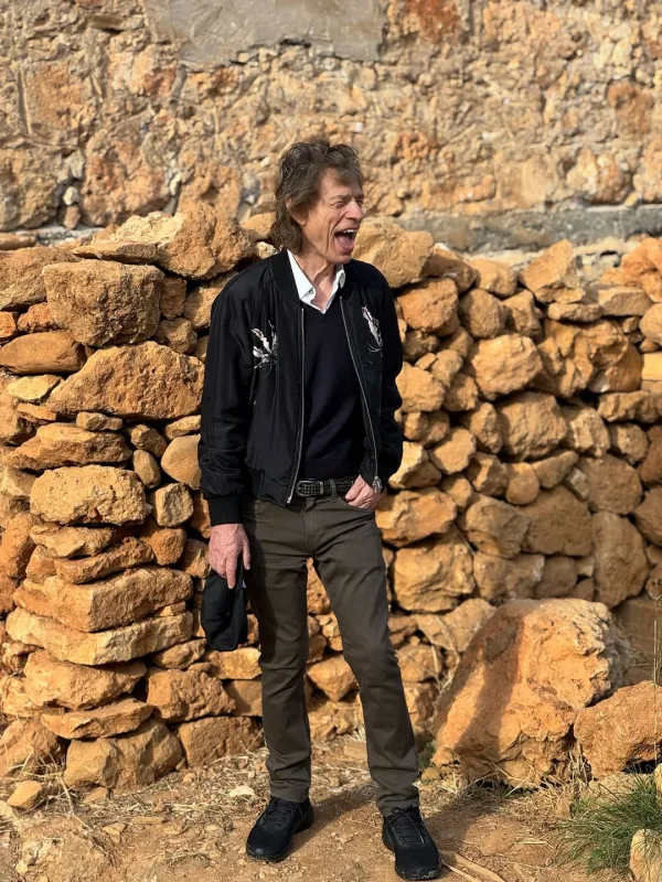 Ο Mick Jagger ποζάρει μπροστά από έναν πέτρινο τοίχο στην Κρήτη.