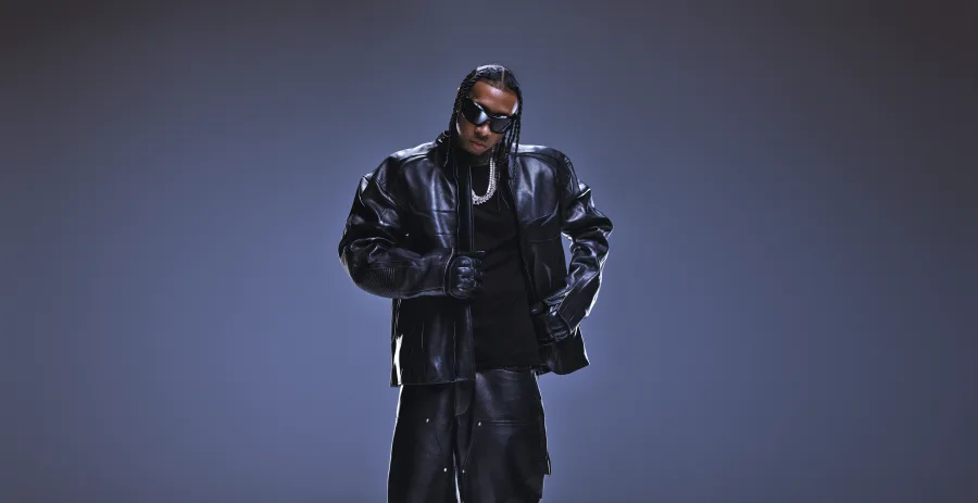 Ο Tyga με μαύρο δερμάτινο τζάκετ, γυαλιά ηλίου και αλυσίδες.