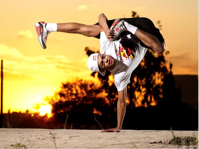 Breakdancer κάνει κατακόρυφο με το ένα χέρι κατά τη διάρκεια του ηλιοβασιλέματος.