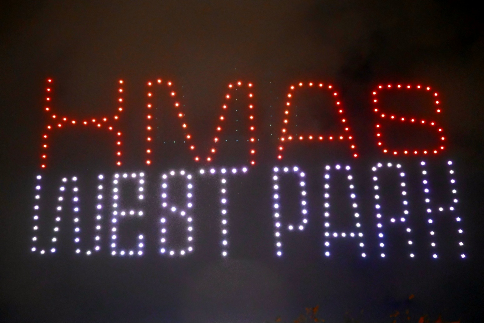 Drone show στον νυχτερινό ουρανό που σχηματίζει τις λέξεις XMAS WEST PARK.