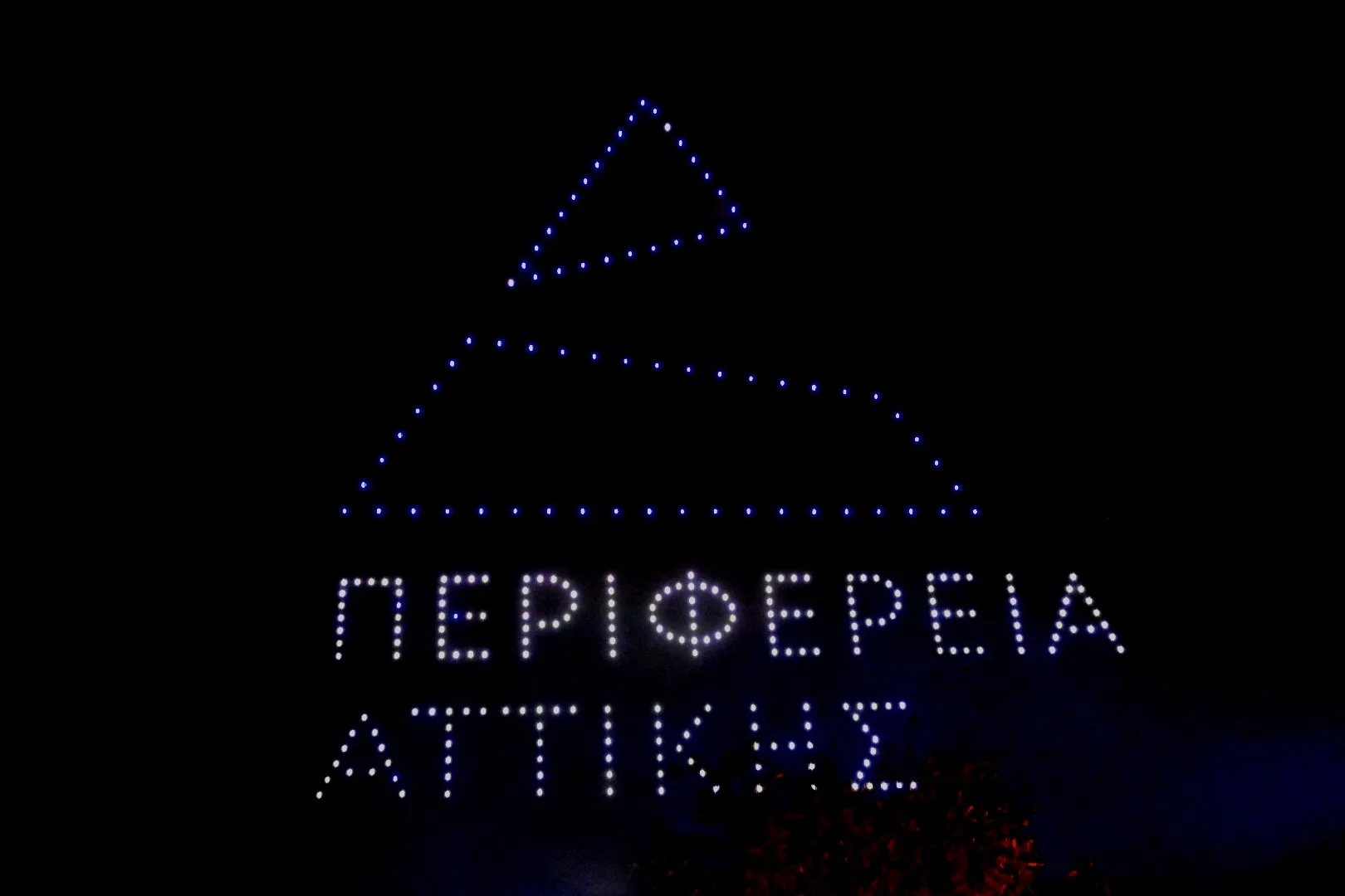 Drone show στον νυχτερινό ουρανό με το λογότυπο της Περιφέρειας Αττικής.