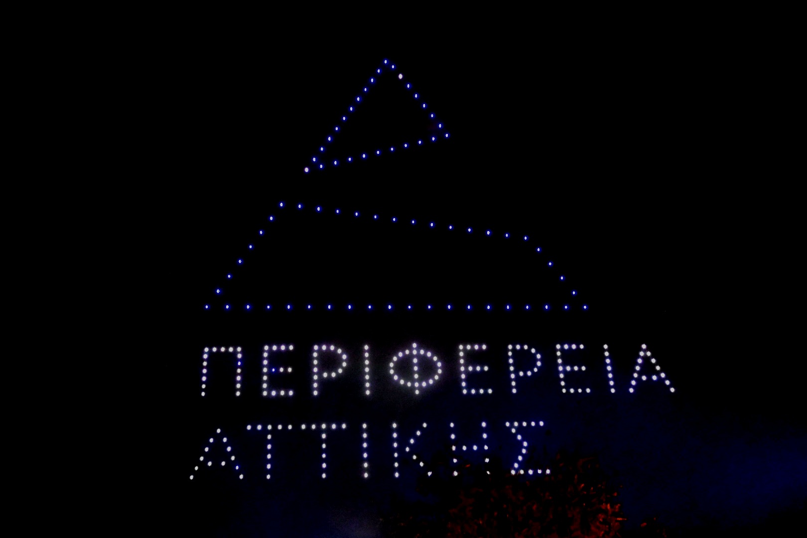 Drone show στον νυχτερινό ουρανό με το λογότυπο της Περιφέρειας Αττικής.
