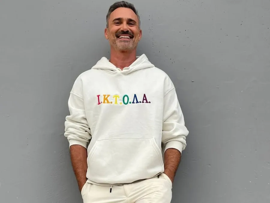 Ο Γιώργος Καπουτζίδης μπαίνει στη σειρά Το Σόι Σου με ρόλο-έκπληξη, φορώντας ένα λευκό φούτερ με πολύχρωμες λεπτομέρειες.