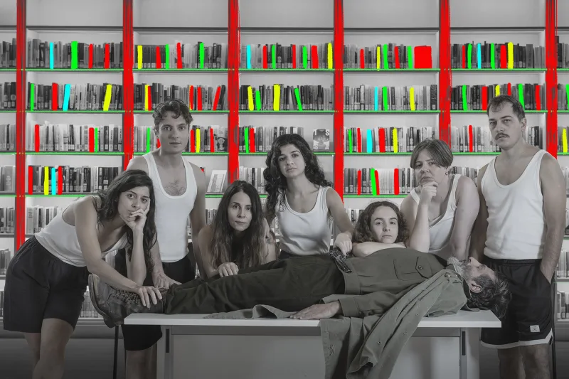 Ομάδα ηθοποιών σε σκηνικό βιβλιοθήκης για την παράσταση ΚΑΠΟΥΤ / Πόλεμος, ένα Vaudeville.