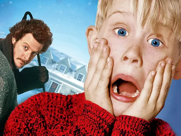Ο Kevin McCallister με έκφραση σοκ και ένας άνδρας με λοστό στο φόντο.