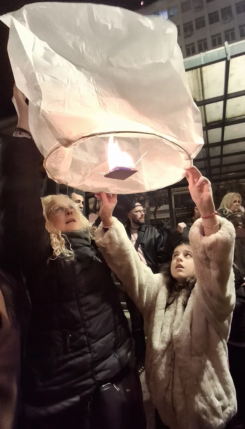 Μια γυναίκα και ένα κορίτσι κρατούν ένα φωτεινό φαναράκι στην πλατεία Κοτζιά.