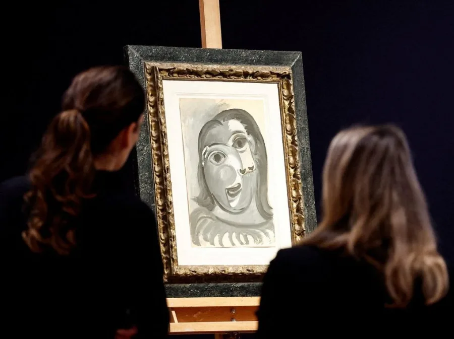 Πίνακας του Picasso σε καβαλέτο με δύο γυναίκες να τον παρατηρούν.