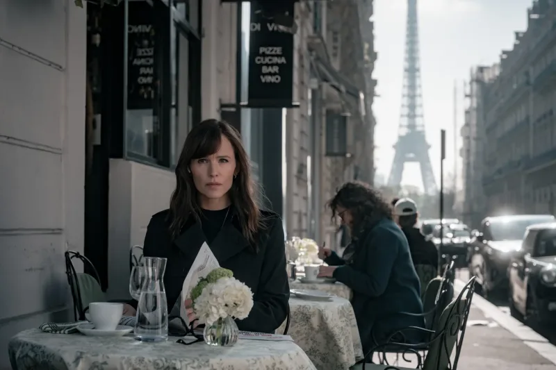 Η Jennifer Garner κάθεται σε καφέ στο Παρίσι, με τον Πύργο του Άιφελ στο φόντο, σε σκηνή από επερχόμενη σειρά.