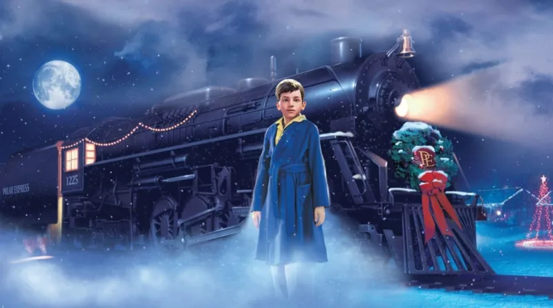 Αγόρι με μπλε ρόμπα μπροστά από το τρένο Polar Express σε χιονισμένο τοπίο.