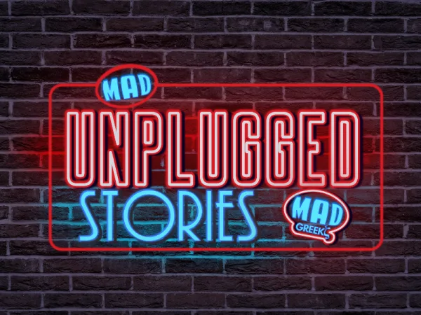 Λογότυπο της εκπομπής Unplugged Stories σε φόντο με τούβλα.
