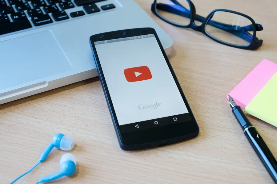 Εικονίδιο του YouTube σε φόντο που παραπέμπει σε τεχνητή νοημοσύνη και ψηφιακή δημιουργία περιεχομένου.