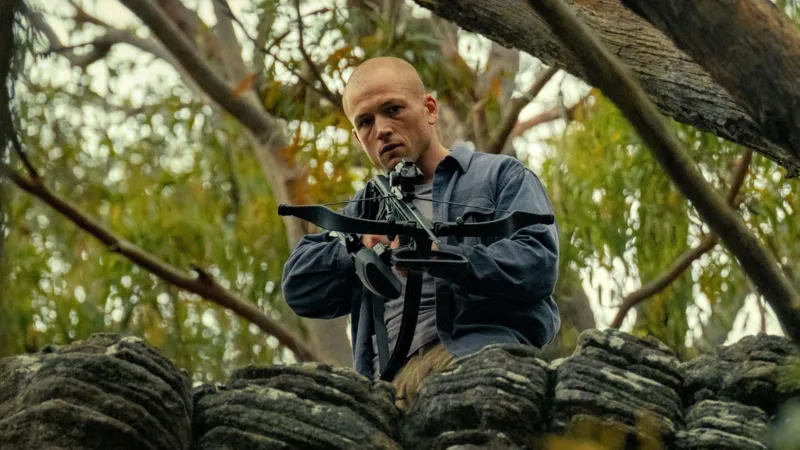Ο Taron Egerton κρατάει μια βαλλίστρα στην ταινία Apex.