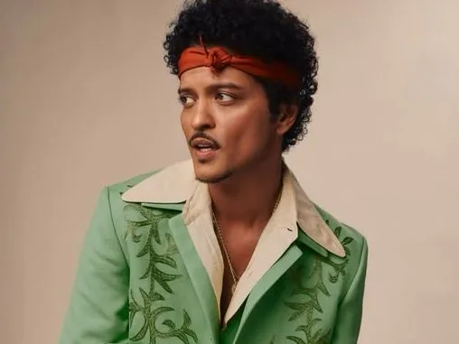 Ο Bruno Mars με πράσινο κεντητό σακάκι και κόκκινη κορδέλα στα μαλλιά.