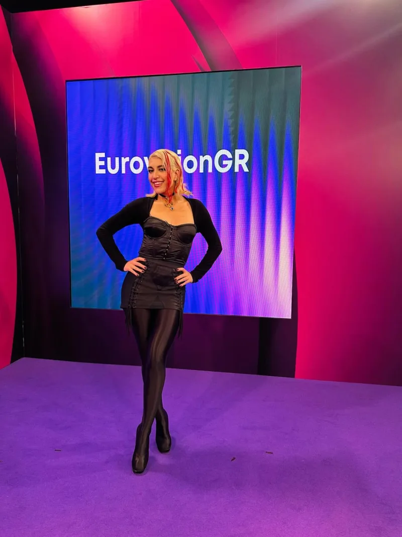 Η Kianna ποζάρει μπροστά από την οθόνη του EurovisionGR, ετοιμάζοντας το τραγούδι της για τον ελληνικό τελικό της Eurovision 2026.