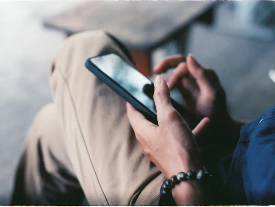Κοντινό πλάνο χεριών που χρησιμοποιούν smartphone.