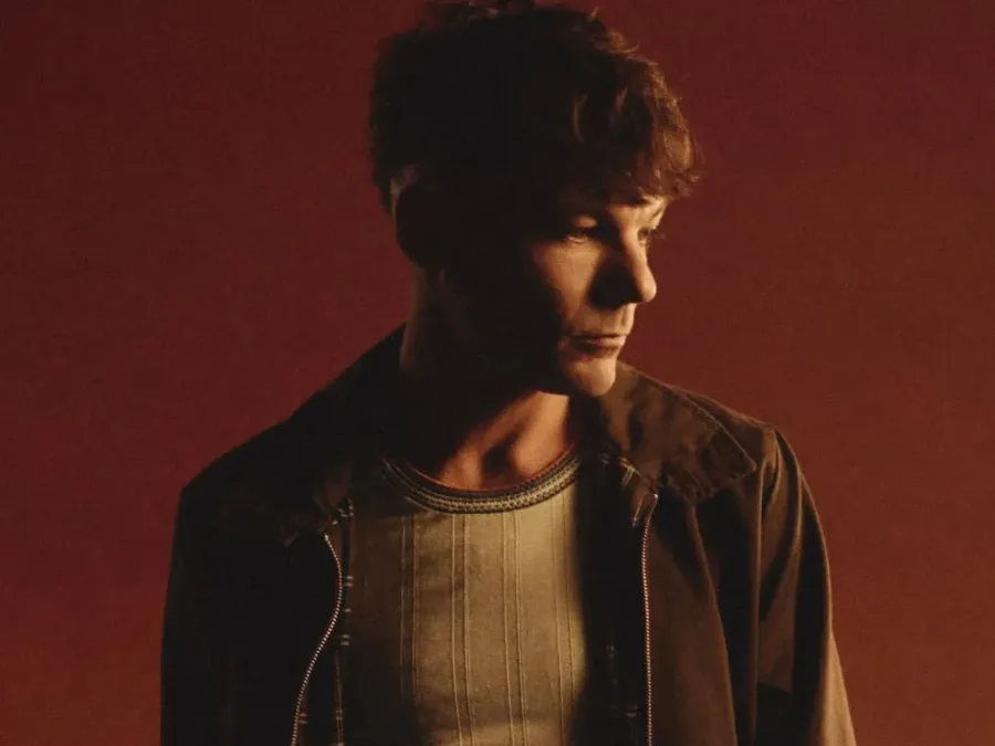 Ο Louis Tomlinson σε προφίλ με καφέ φόντο