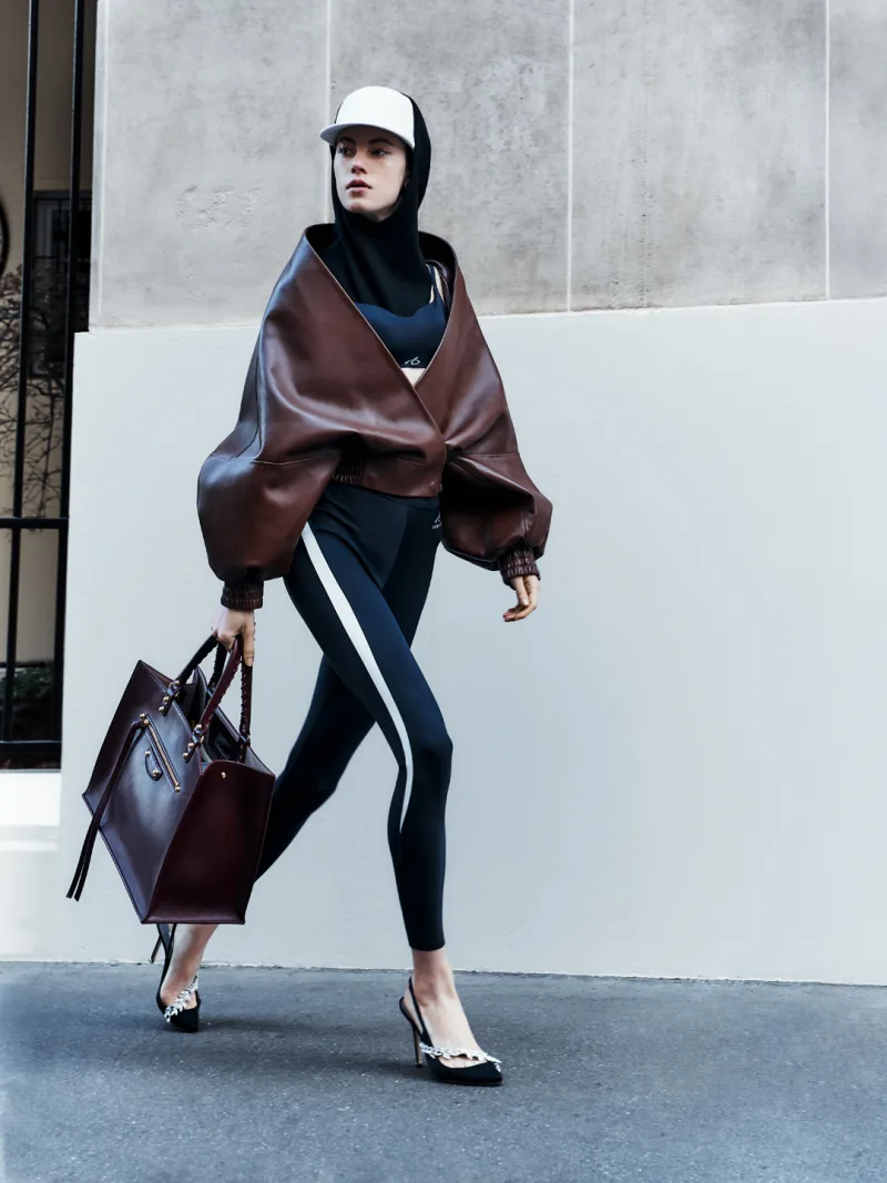 Μοντέλο με δερμάτινο τζάκετ Balenciaga, κολάν και γόβες Manolo Blahnik σε αστικό περιβάλλον.