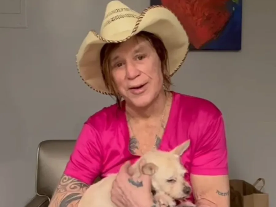 Ο Mickey Rourke με καουμπόικο καπέλο κρατάει ένα μικρό σκυλάκι.