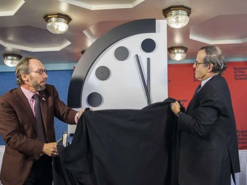 Δύο άνδρες αποκαλύπτουν το Doomsday Clock, το οποίο συμβολίζει την αντίστροφη μέτρηση για τον πλανήτη.