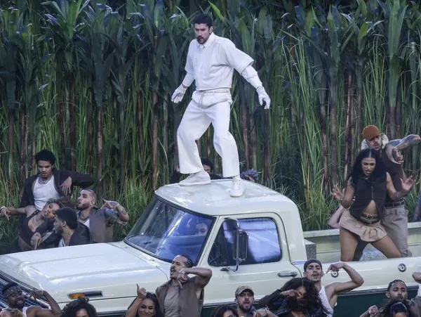 Ο Bad Bunny στέκεται πάνω σε ένα φορτηγό κατά τη διάρκεια της εμφάνισής του στο Super Bowl, πλαισιωμένος από χορευτές.