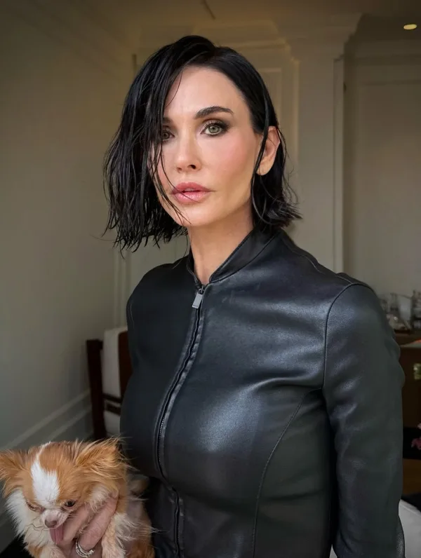 Η Demi Moore με κοντό hair look και δερμάτινο jacket στο show του οίκου Gucci, κρατώντας το σκυλάκι της.