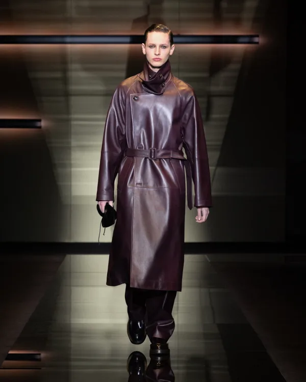 Μοντέλο στην επίδειξη Emporio Armani F/W 26-27 με μακρύ δερμάτινο παλτό σε μπορντό χρώμα.