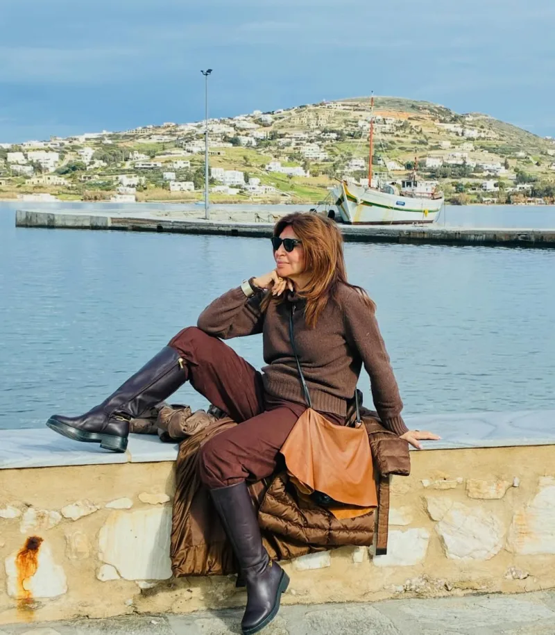 Γυναίκα με καφέ ρούχα ποζάρει σε παραθαλάσσιο τοπίο, με την ΕΡΤ και τη νέα σειρά να αποτελούν το θέμα του άρθρου.