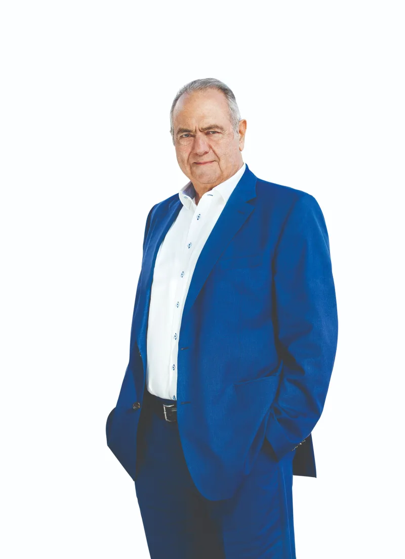 Ο Γιώργος Γεράρδος με μπλε κοστούμι και λευκό πουκάμισο.