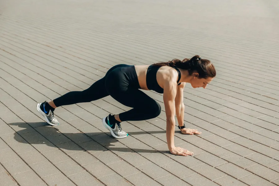 Γυναίκα εκτελεί άσκηση mountain climber, ένα από τα fitness μυστικά που αποκαλύπτονται στο άρθρο.