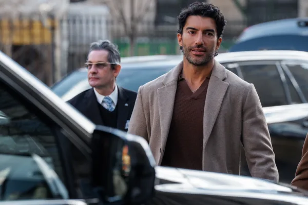 Ο Justin Baldoni με κοστούμι και παλτό, συνοδευόμενος από άνδρα με γυαλιά, σε σκηνή από την πολύκροτη υπόθεση.