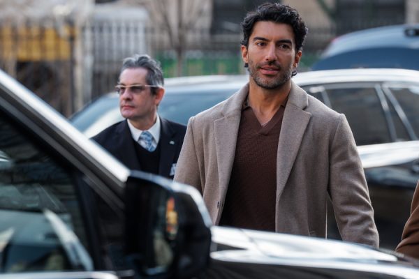 Ο Justin Baldoni με κοστούμι και παλτό, συνοδευόμενος από άνδρα με γυαλιά, σε σκηνή από την πολύκροτη υπόθεση.