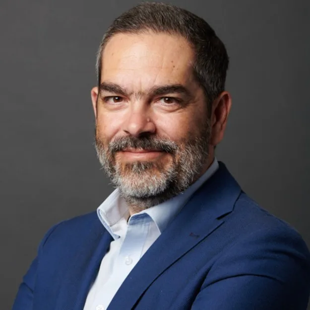 Πορτρέτο άνδρα με μούσια, μπλε σακάκι και γαλάζιο πουκάμισο.
