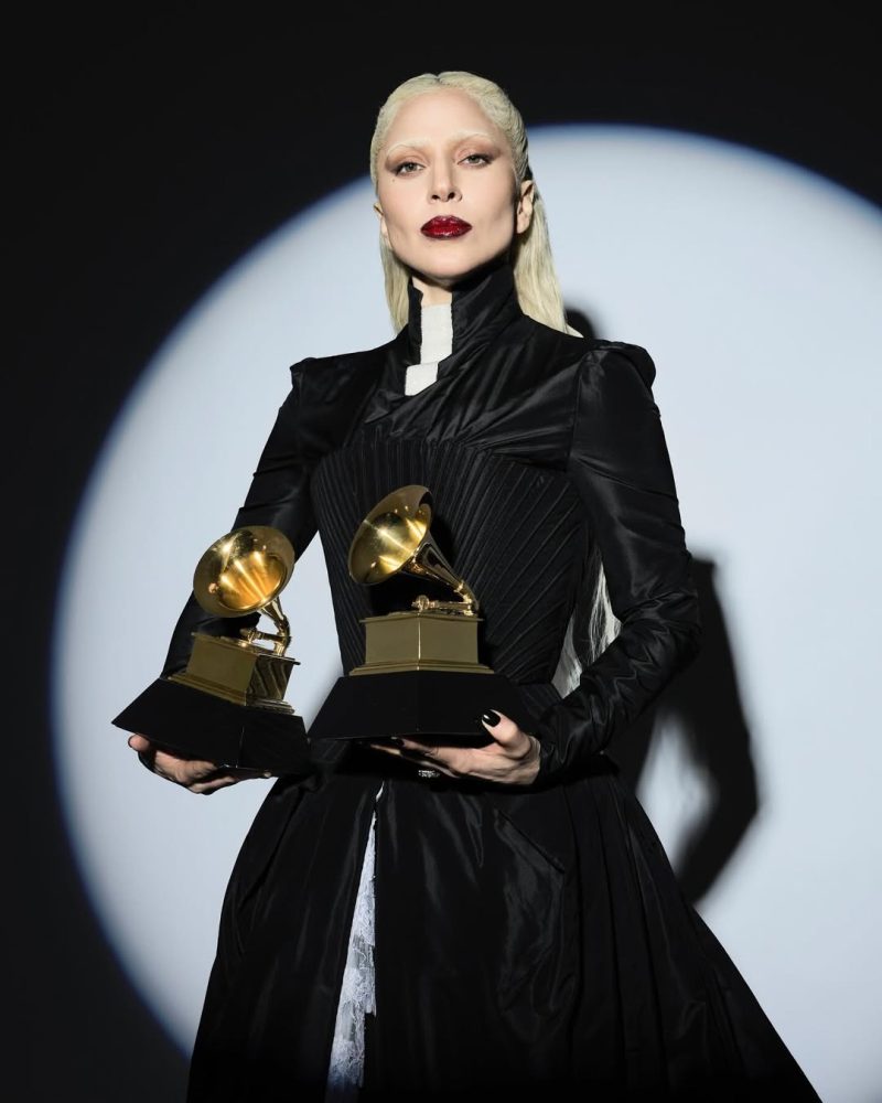 Η Lady Gaga ποζάρει με τα βραβεία Grammy 2026 για την επιτυχία της στην Dance Pop και το Ποπ Φωνητικό Άλμπουμ.
