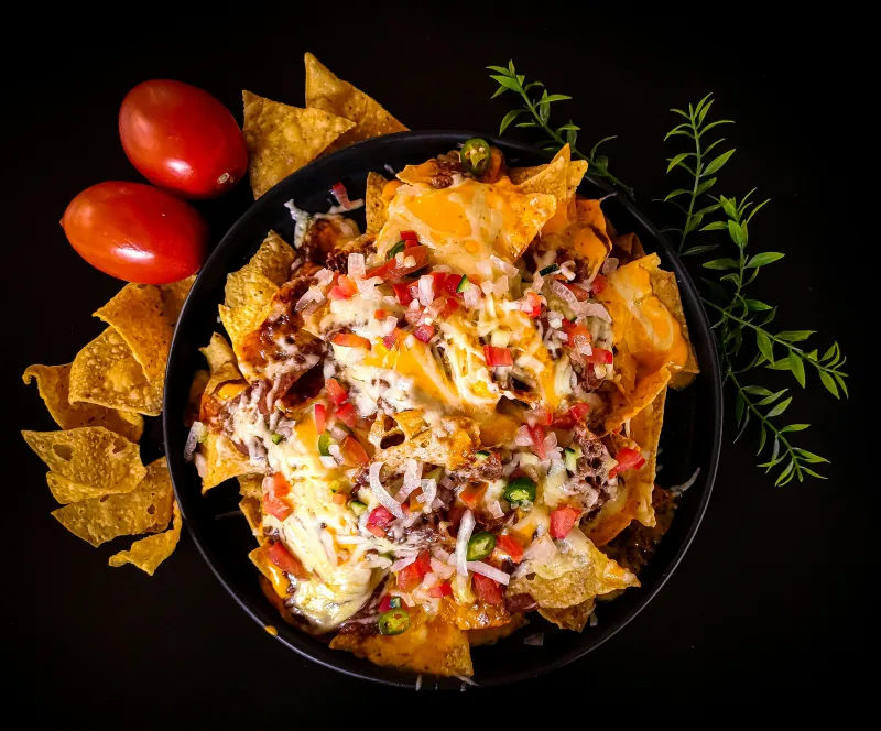Λαχταριστά nachos με λιωμένο τυρί και υλικά για game day στο σπίτι.
