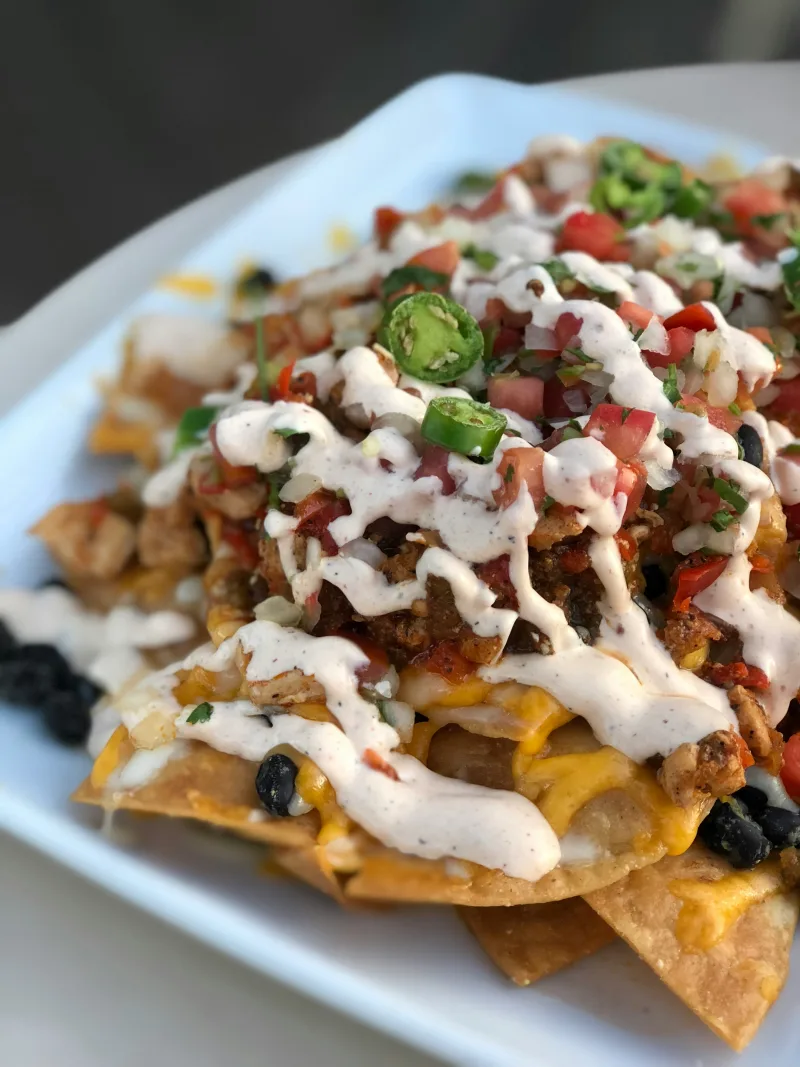 Λαχταριστά nachos με λιωμένο τυρί και υλικά για game day στο σπίτι.