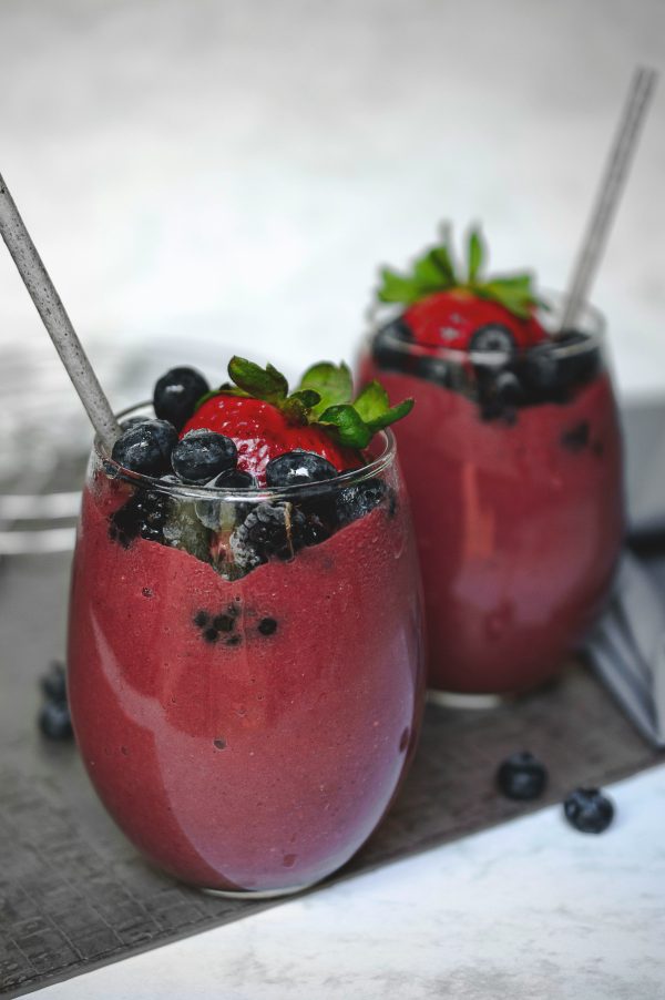 Ποικιλία από superfoods και υλικά για θρεπτικά smoothies σε ξύλινη επιφάνεια.