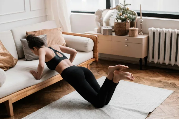 Γυναίκα εκτελεί άσκηση push-up με τα γόνατα λυγισμένα, μια από τις προτεινόμενες ασκήσεις για γρήγορη αλλαγή σώματος.