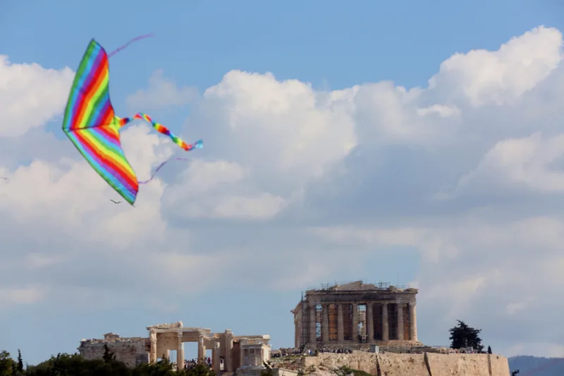Χρωματιστός χαρταετός πετάει ψηλά στον ουρανό πάνω από την Ακρόπολη, προσφέροντας συμβουλές για το πέταγμα.