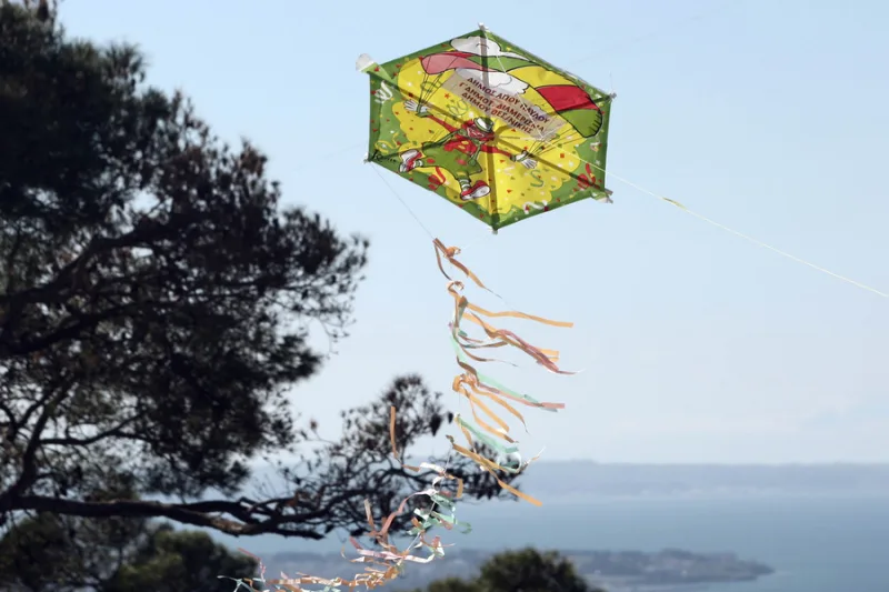 Ένας πολύχρωμος χαρταετός με κορδέλες πετάει ψηλά στον ουρανό, προσφέροντας συμβουλές για το πέταγμα.