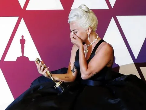 Η Lady Gaga κρατάει το Όσκαρ της και δακρύζει, γιορτάζοντας την επιτυχία της με τον Michael Polansky.