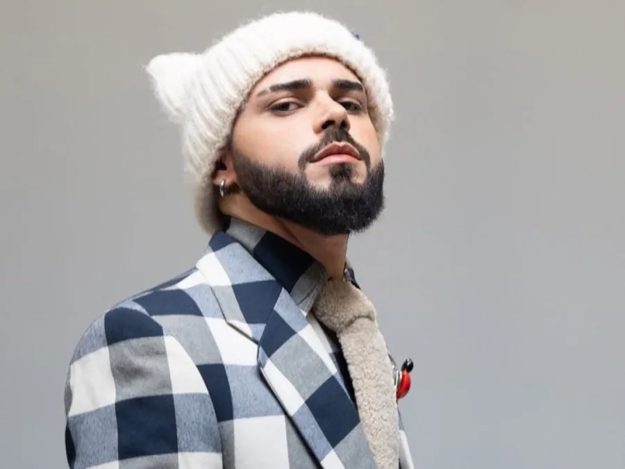 Ο Akylas ποζάρει με σκούφο και καρό σακάκι, αποκαλύπτοντας λεπτομέρειες για την εμφάνισή του στη Eurovision.