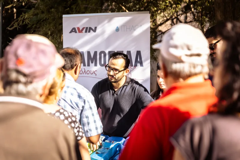 Άνδρας με γυαλιά σε εκδήλωση της Motor Oil με το λογότυπο AVIN.