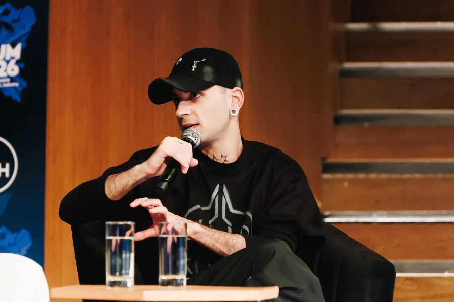 Ο TEO.x3 μιλάει στο MAD Forum 2026 κρατώντας μικρόφωνο.