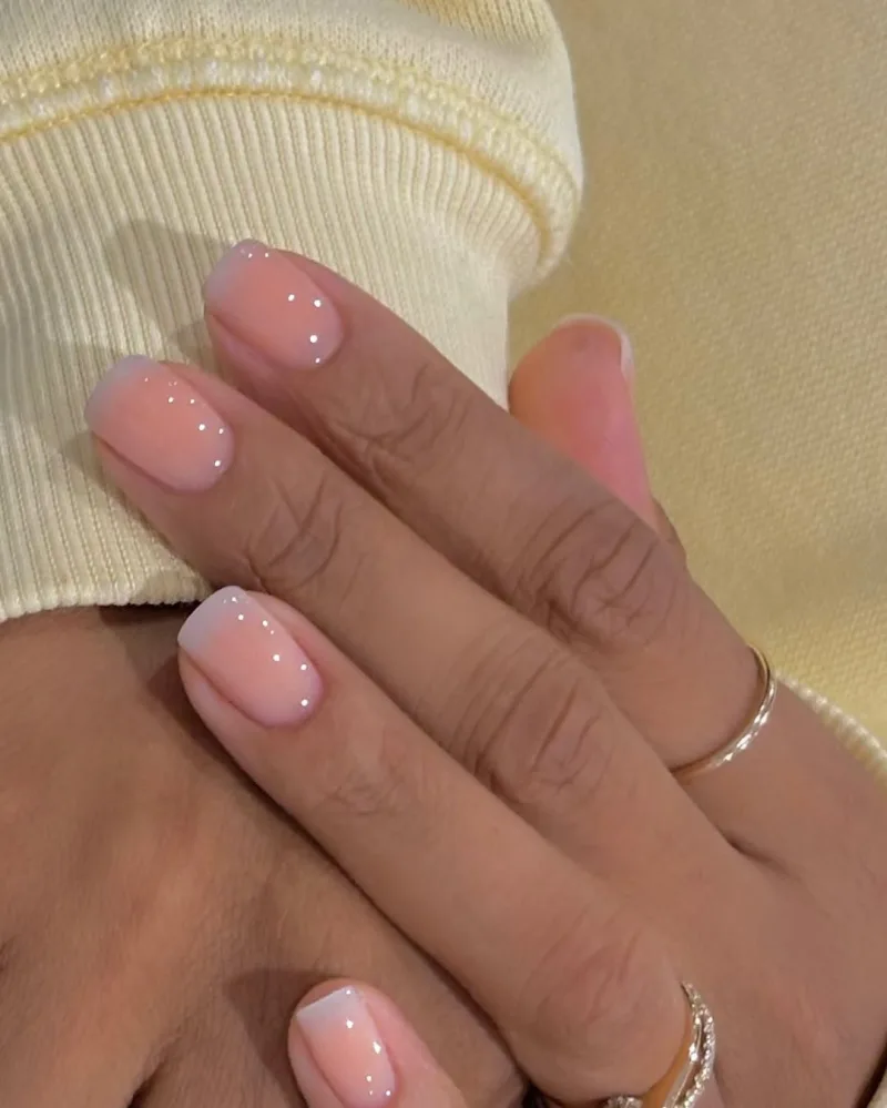 Πασχαλινά nail arts με απαλή ροζ βάση και διακριτικές λευκές βούλες για ένα κομψό μανικιούρ.