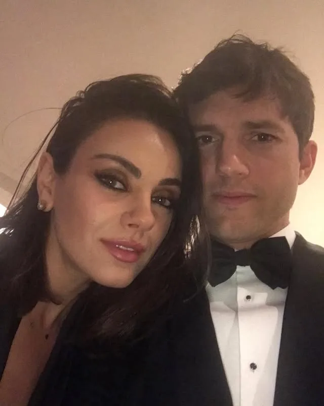 Ashton Kutcher και Mila Kunis ποζάρουν χαμογελαστοί, αναδεικνύοντας την πολυτέλεια του σπιτιού τους στο Los Angeles.